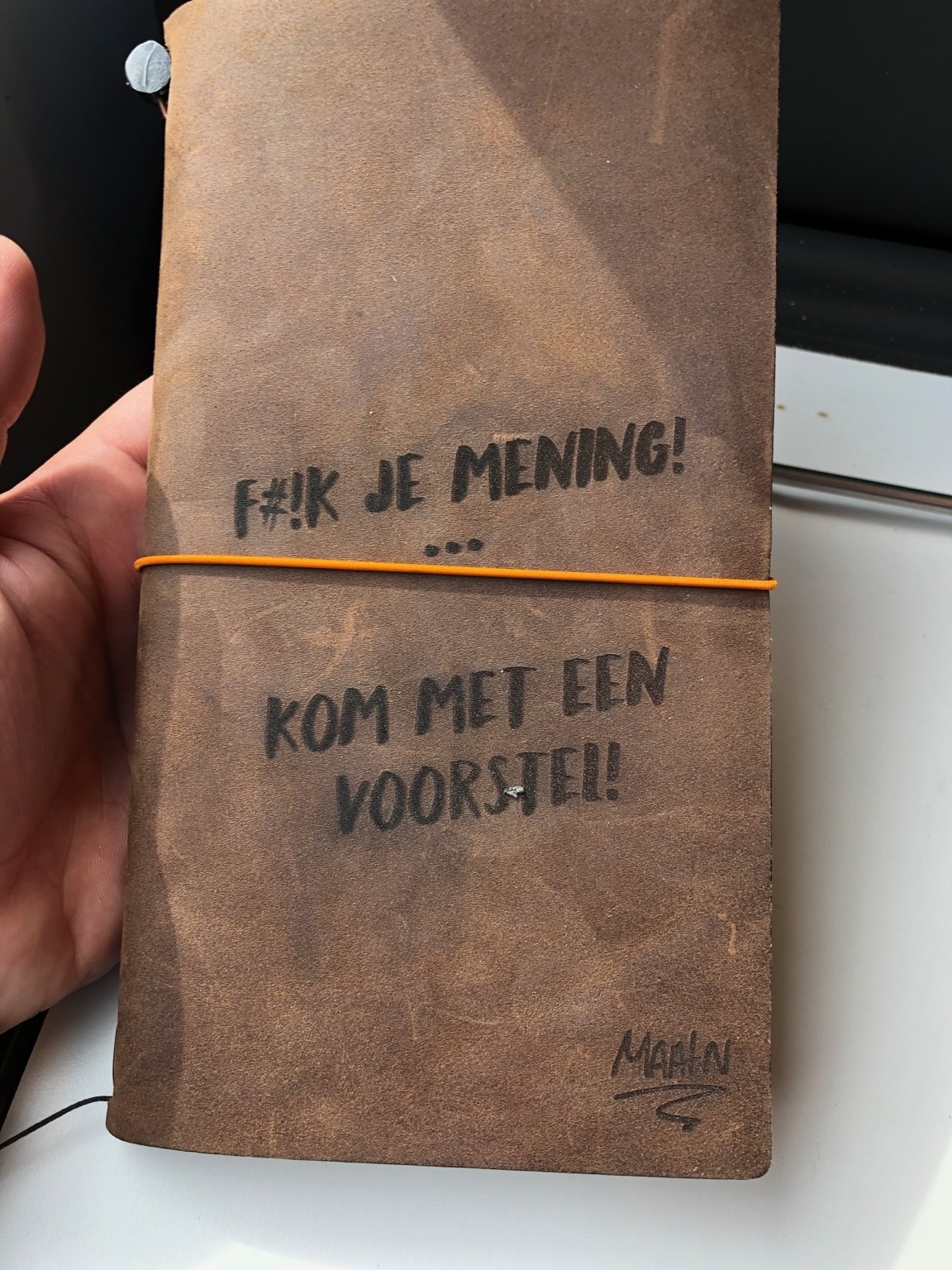 Notitieboek met de tekst: F#ck je mening, kom met een voorstel